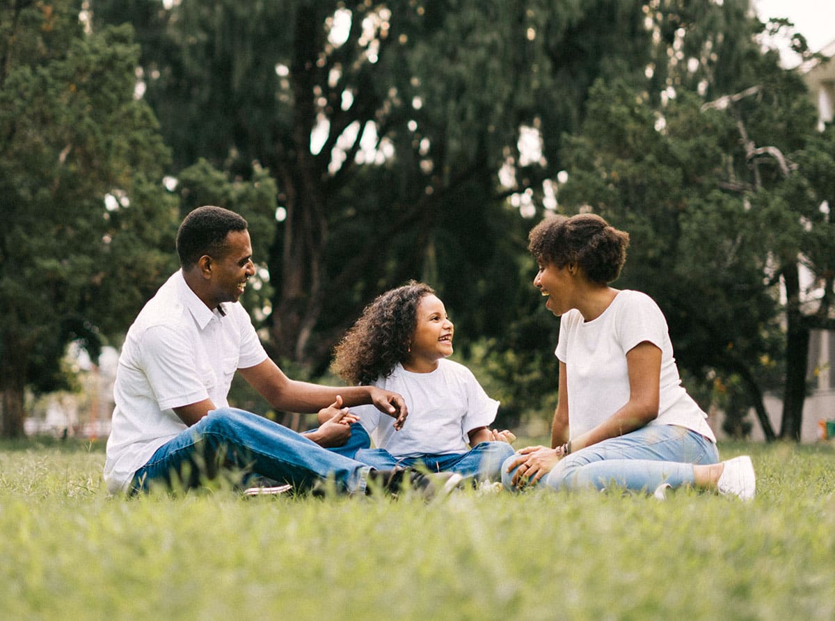 family sits on grass